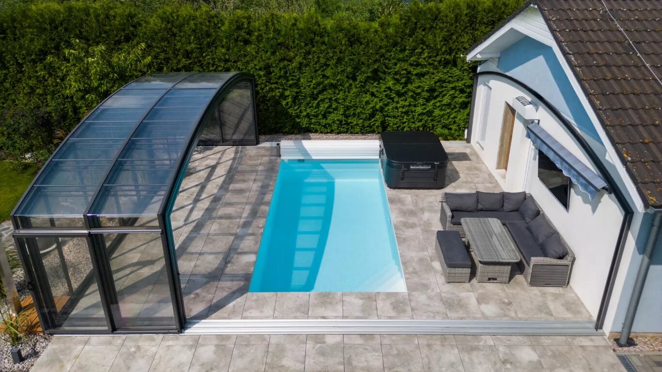 Acoperire înaltă de piscină, retrasă lângă bazin, cu spațiu de trecut pe dedesubt